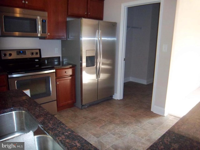 kitchen featuring appliances with stainless steel finishes and dark stone counters