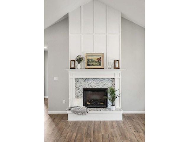 interior space featuring hardwood / wood-style flooring, a tile fireplace, and high vaulted ceiling