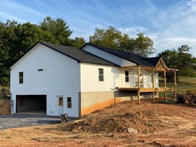 view of side of home with a garage and a porch