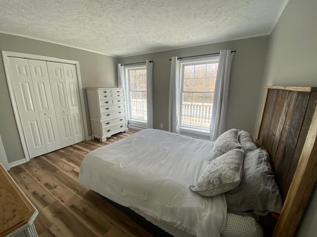 bedroom featuring a closet, a textured ceiling, and wood finished floors