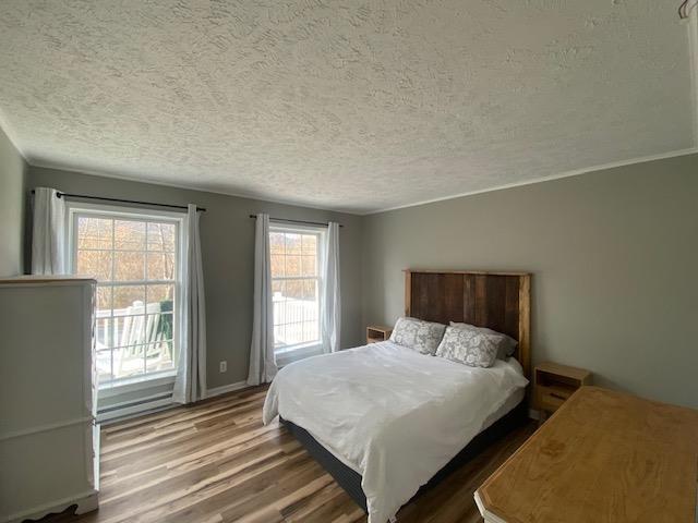 bedroom featuring a textured ceiling and wood finished floors