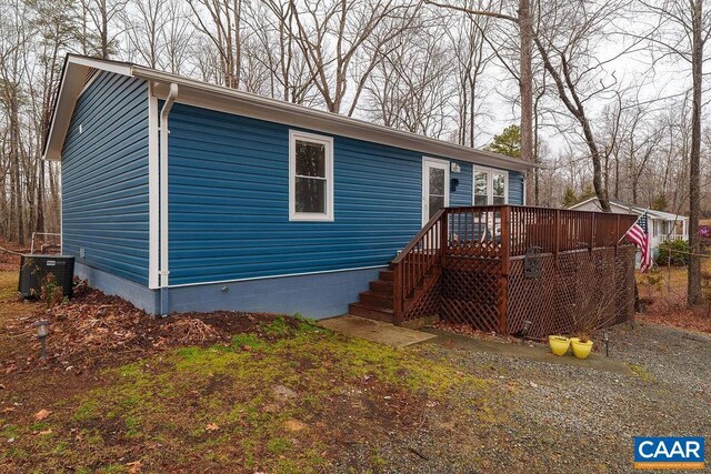 view of front of property featuring central AC and a wooden deck