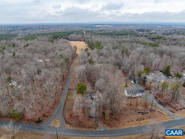 drone / aerial view with a wooded view and a rural view