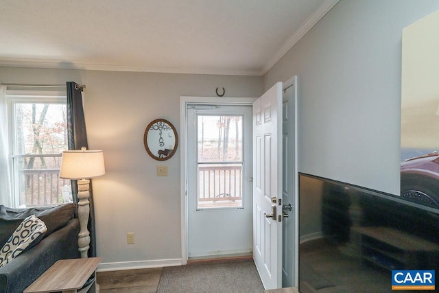 entryway with plenty of natural light, baseboards, crown molding, and wood finished floors