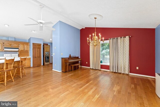 living room featuring ceiling fan with notable chandelier, vaulted ceiling, and light wood-type flooring