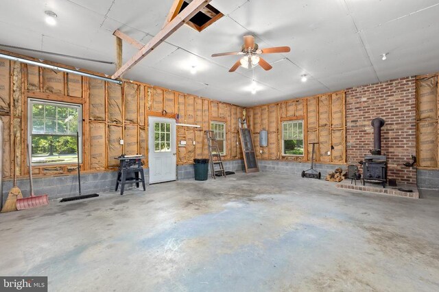 garage featuring ceiling fan and a wood stove