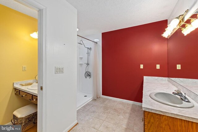 bathroom featuring vanity, tile patterned floors, a textured ceiling, and walk in shower