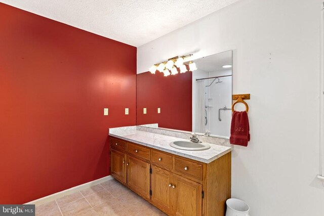 bathroom featuring vanity, tile patterned floors, and a textured ceiling