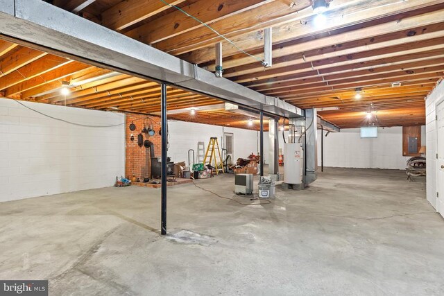 basement featuring electric panel and water heater