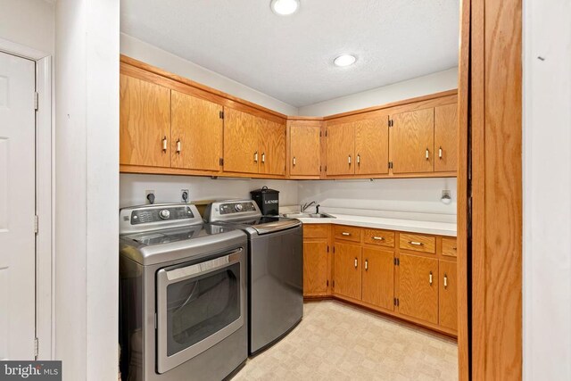 laundry area featuring cabinets, sink, and independent washer and dryer