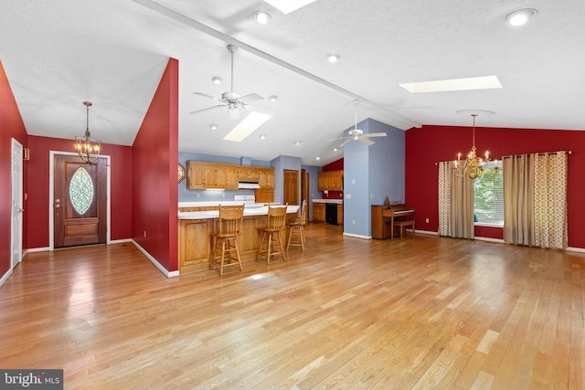 kitchen featuring a kitchen bar, hanging light fixtures, and light wood-type flooring