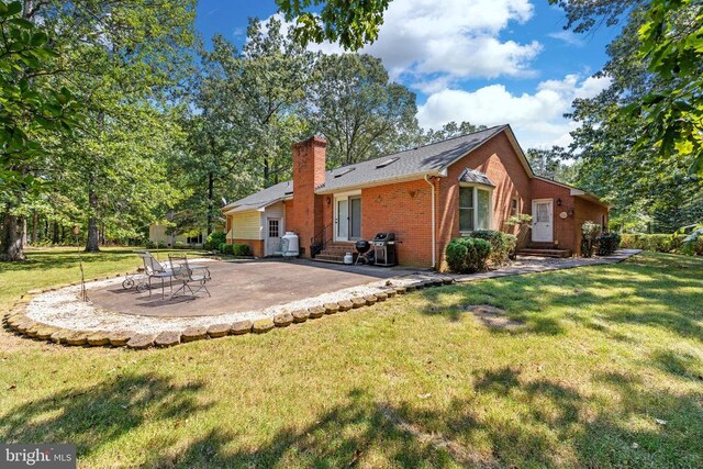 back of house with a yard and a patio