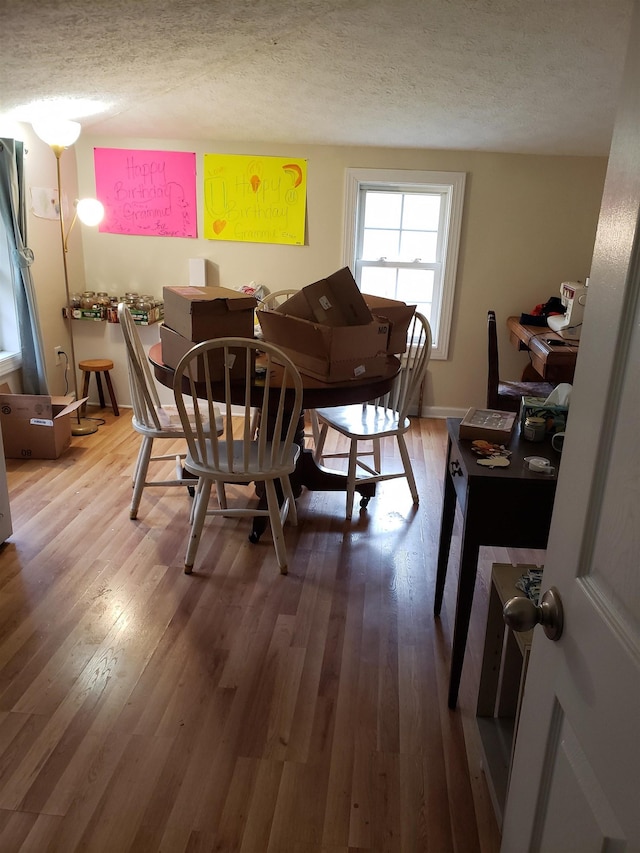 dining area with hardwood / wood-style flooring and a textured ceiling