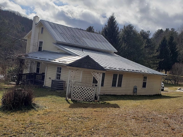 view of side of home featuring central air condition unit and a lawn