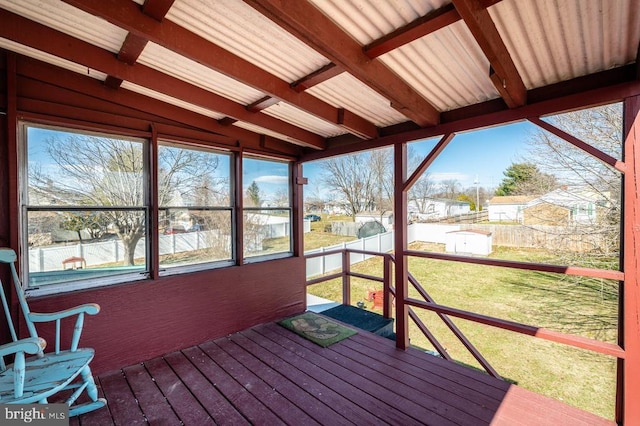 unfurnished sunroom featuring beamed ceiling