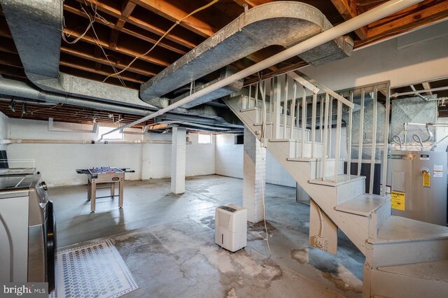 basement featuring washer and dryer, electric water heater, and stairs