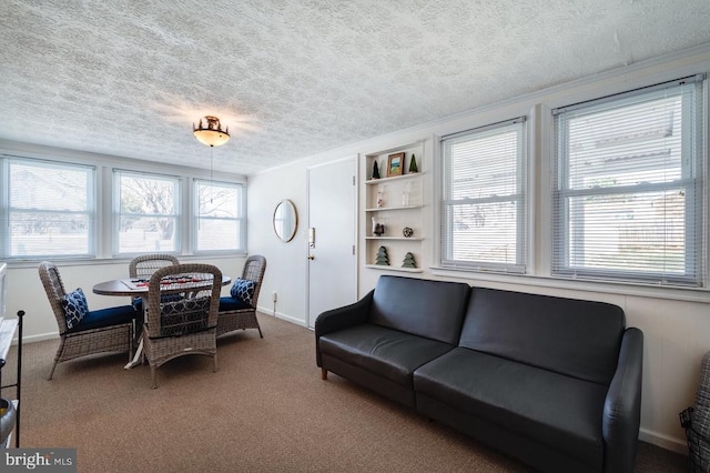 dining area with baseboards, a textured ceiling, and carpet flooring