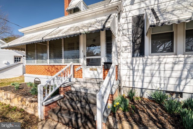 entrance to property featuring brick siding