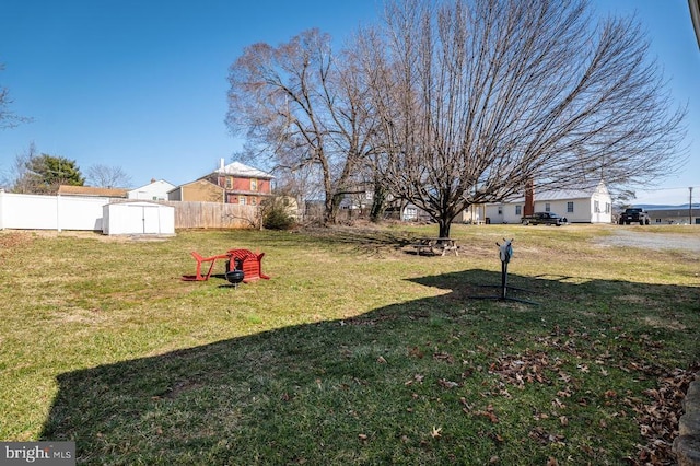 view of yard with an outbuilding, fence, and a shed