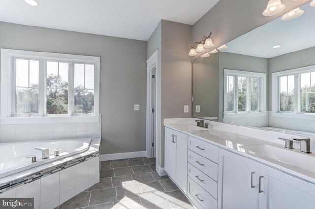 bathroom with vanity, tile patterned floors, and tiled bath