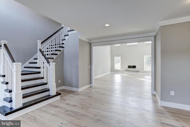 entryway featuring crown molding and light hardwood / wood-style flooring