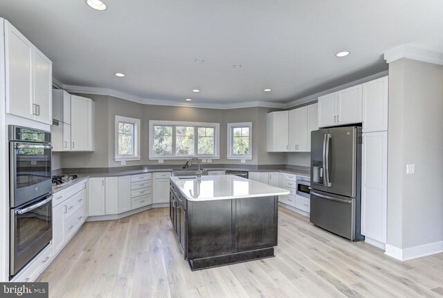 kitchen featuring white cabinetry, appliances with stainless steel finishes, and a center island with sink