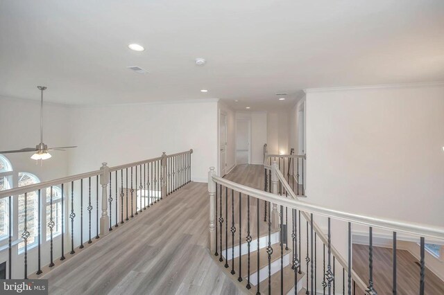 hallway with ornamental molding and light wood-type flooring