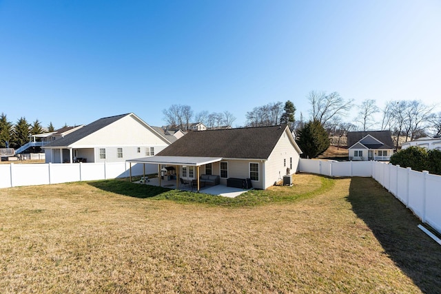 rear view of property with a fenced backyard, cooling unit, a patio, and a yard