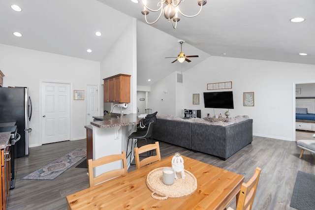 dining area featuring recessed lighting, ceiling fan with notable chandelier, and dark wood-type flooring