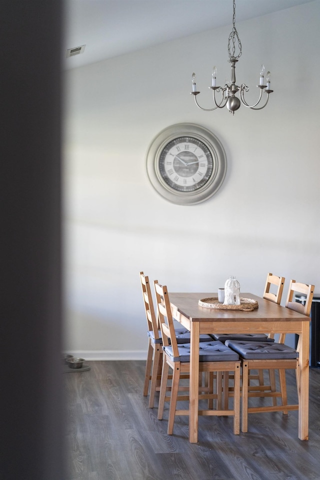 dining space with an inviting chandelier, wood finished floors, and baseboards