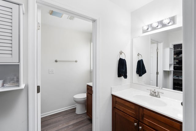 bathroom with vanity, wood finished floors, visible vents, baseboards, and toilet