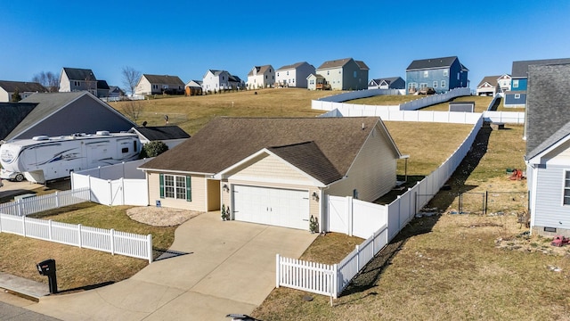 exterior space with driveway, roof with shingles, a fenced backyard, a garage, and a residential view