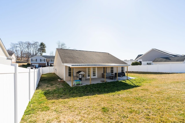 rear view of property with a patio, a lawn, and a fenced backyard