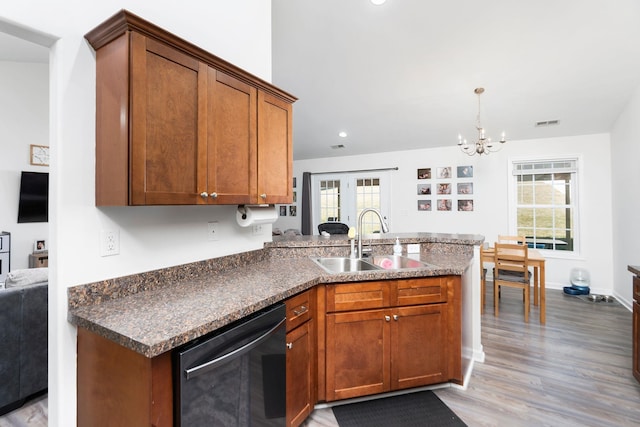 kitchen with a peninsula, a sink, dishwasher, dark countertops, and brown cabinets