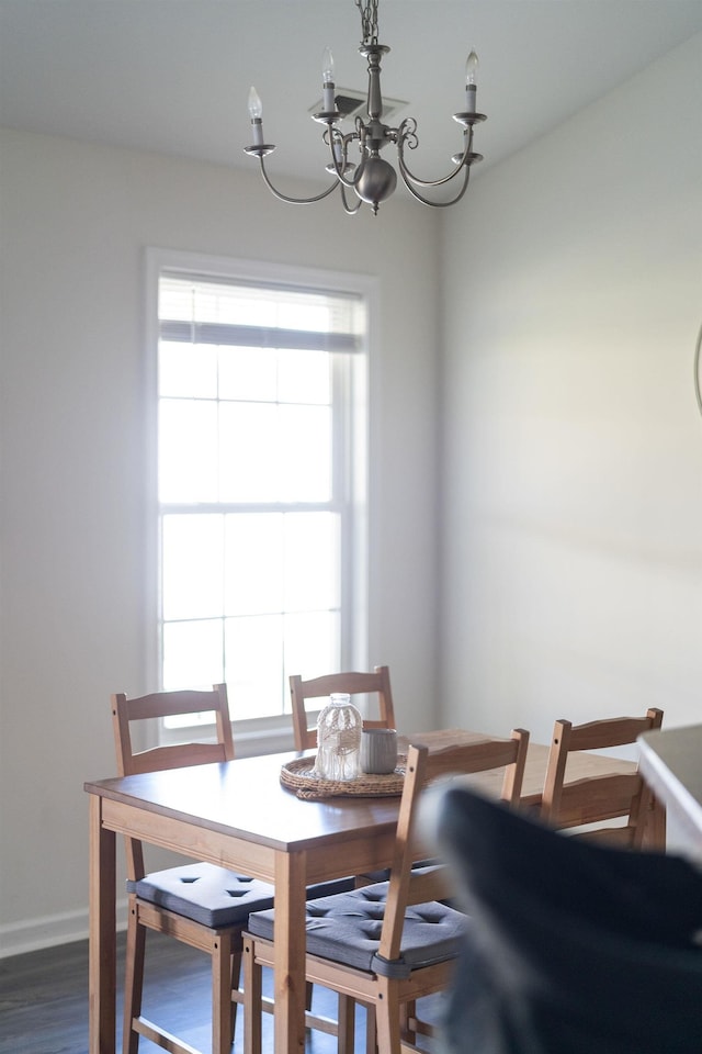 dining room with an inviting chandelier, baseboards, and dark wood-style flooring