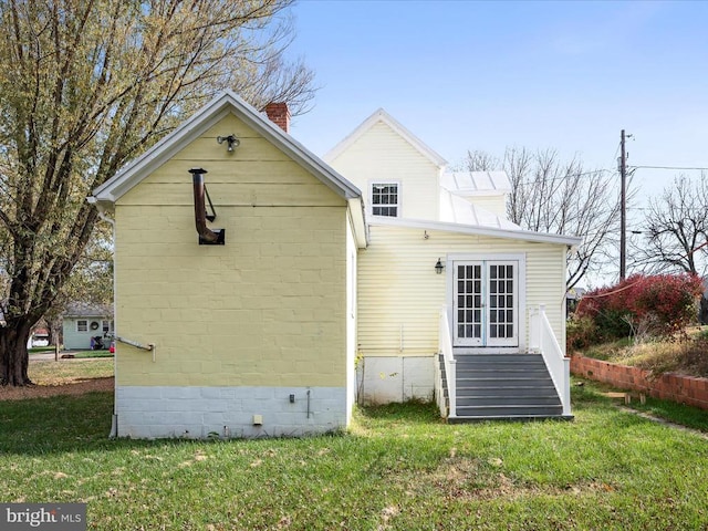 back of property featuring a lawn