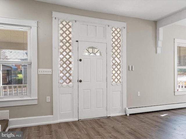 foyer entrance with wood-type flooring and baseboard heating