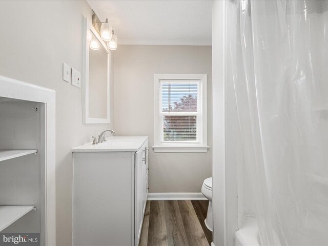 full bathroom with toilet, wood-type flooring, ornamental molding, vanity, and shower / bath combination with curtain