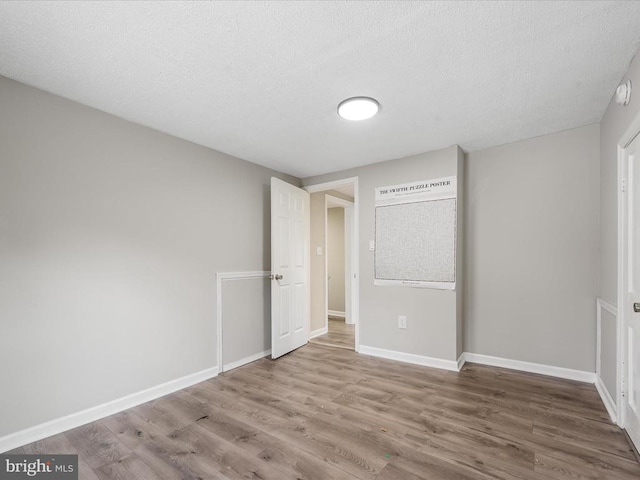 unfurnished bedroom featuring hardwood / wood-style flooring and a textured ceiling