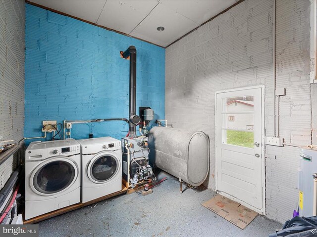 washroom with washing machine and dryer and water heater