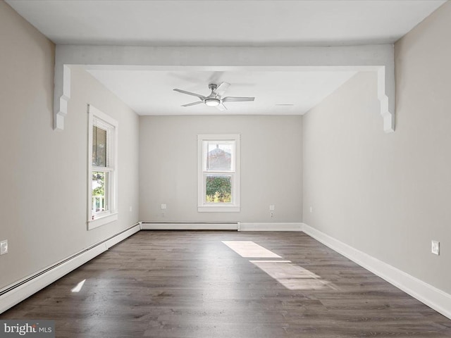 empty room featuring baseboard heating, ceiling fan, dark hardwood / wood-style floors, and a wealth of natural light