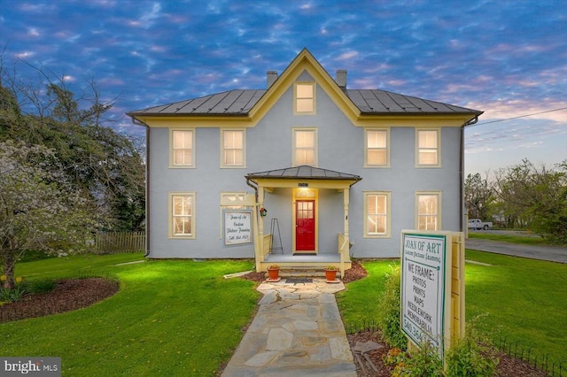 view of front of home featuring solar panels and a lawn