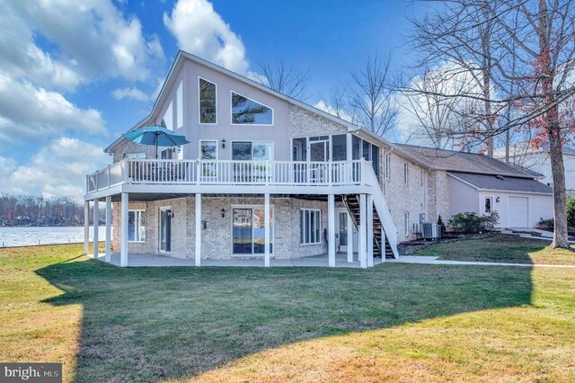 back of property featuring a deck with water view, central AC unit, a yard, and a patio