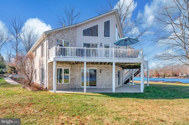 back of house with a wooden deck, a yard, and a patio