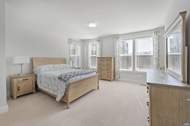 bedroom featuring light carpet and baseboards