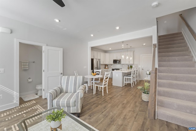 living room with baseboards, stairway, wood finished floors, and recessed lighting