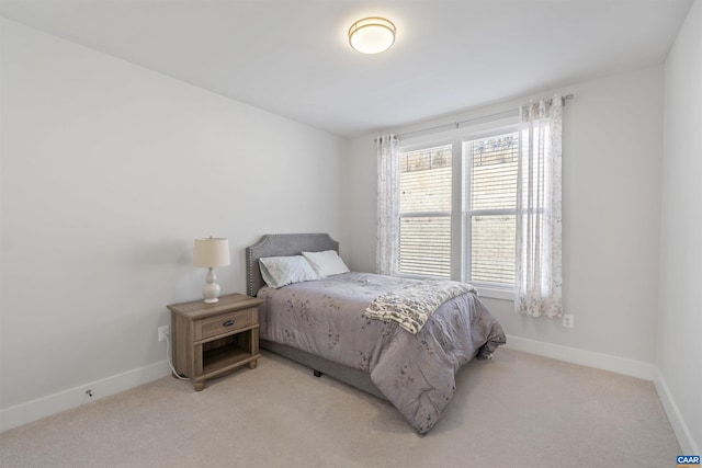 bedroom with baseboards and light colored carpet