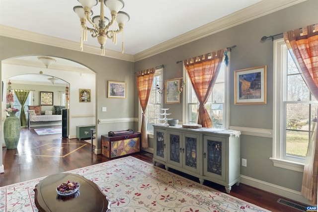 interior space with wood finished floors, visible vents, arched walkways, crown molding, and a chandelier