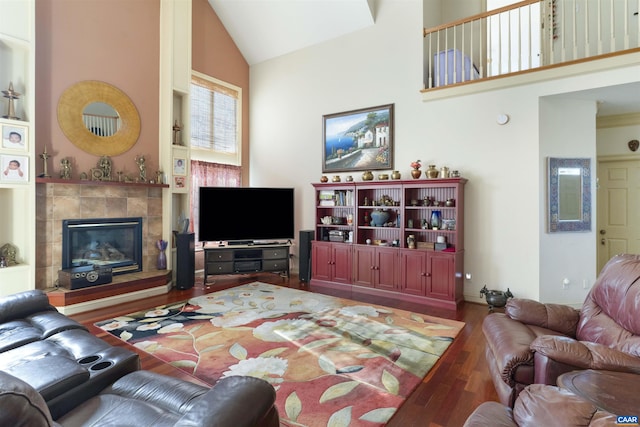 living area featuring high vaulted ceiling, wood finished floors, and a fireplace