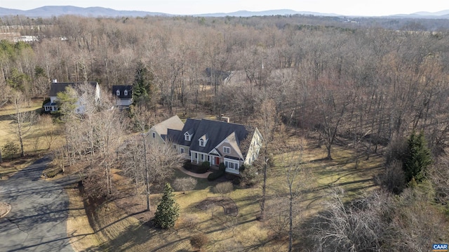 birds eye view of property featuring a forest view and a mountain view